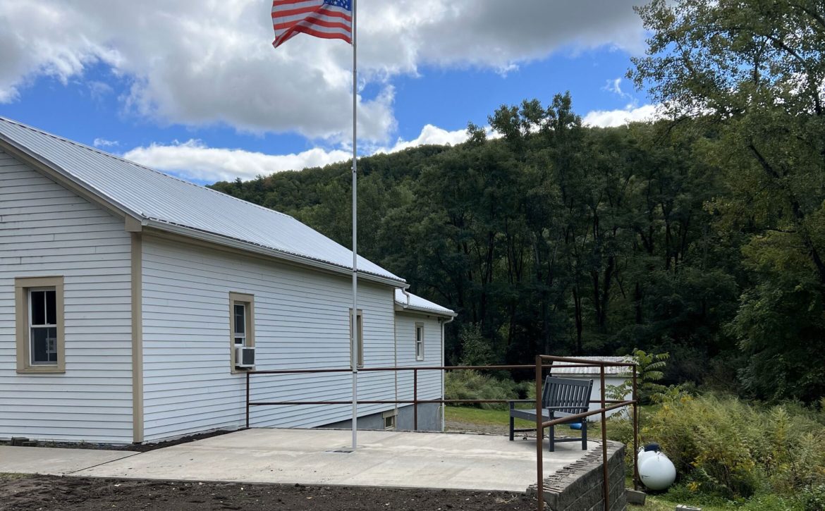 Town of Hartsville memorial area for Darold "Buddy" Getman, paved area with flag pole flying the American flag next to the Town of Hartsville office